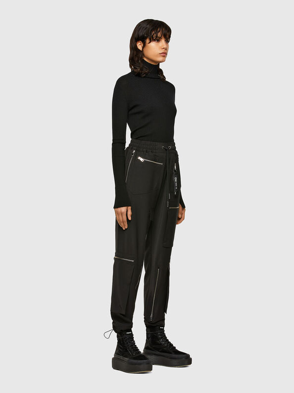 Woman in black cargo pants with a chunky knit turtleneck in winter